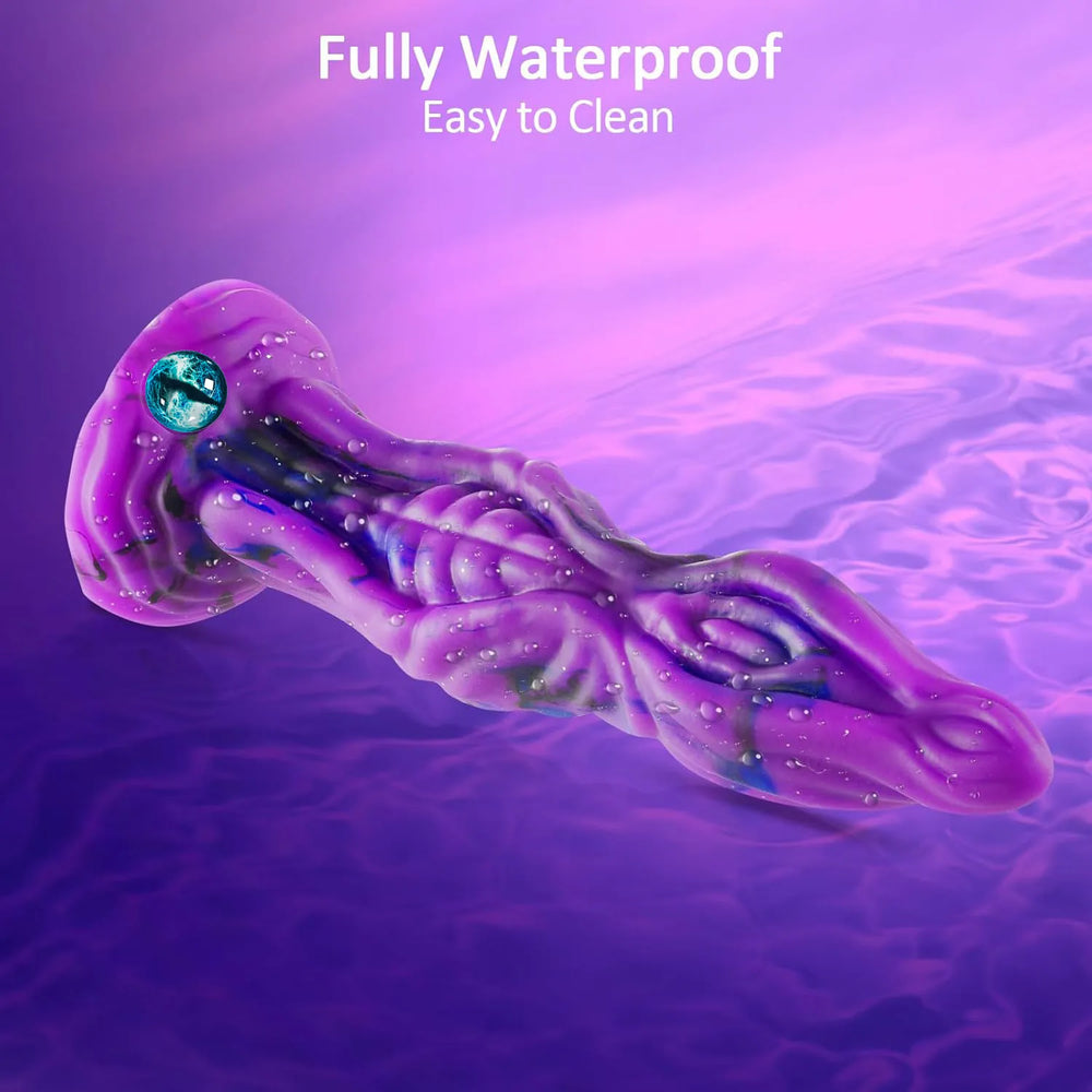 Close-up shot of a textured purple silicone pleasure product with an intricate, otherworldly aesthetic and an embedded eye detail on the stand